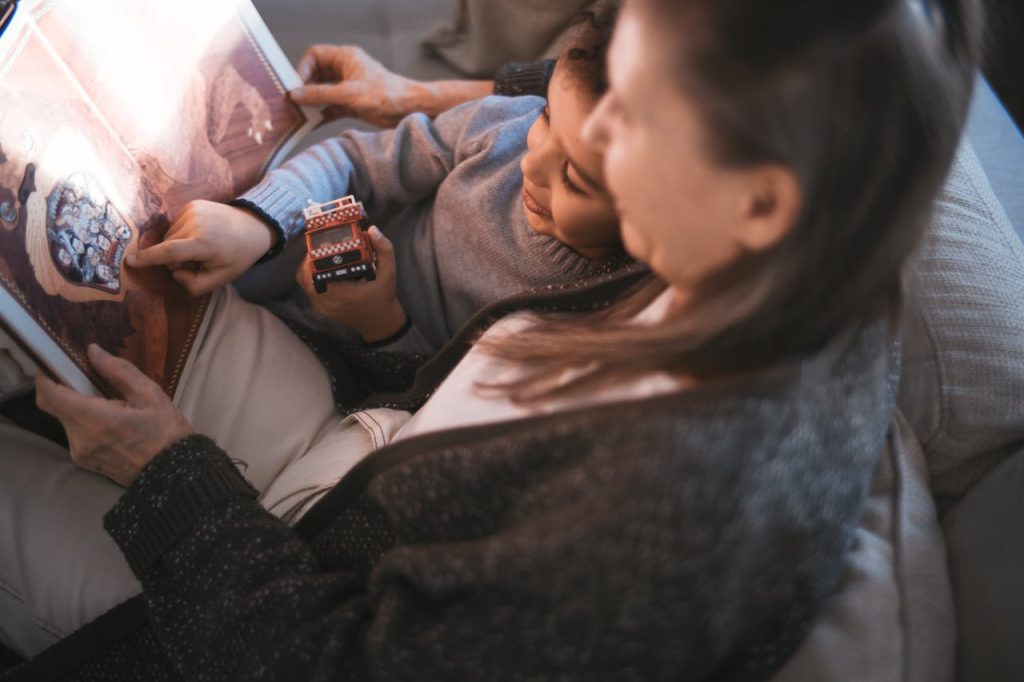 Grandmother and child enjoying a afternoon reading together indoors.