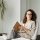 Businesswoman sitting in a modern office with a notebook, exuding professionalism and confidence.